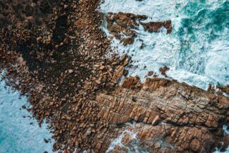 Aerial view of ocean waves crashing on rocks